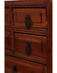 Close-up of vintage Chinese jewelry box with five drawers, dark metal handles, and ornate wood detailing.