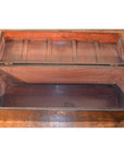 Black lacquer trunk with lid open, showing empty interior, placed on a wooden floor indoors.