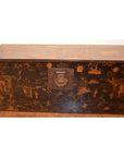 Black lacquered wood Chinese trunk with intricate designs and metal clasp, placed on a wooden floor.