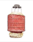 Close-up of a pink wire-wrapped cylindrical lantern with straw accents and metal top, styled like a Chinese paper lantern.