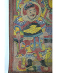 Colorful Laotian parchment painting showing a warrior in ornate armor with staff and lion, traditional art close-up.