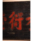 Close-up of dark wood Chinese signboard with bold red Chinese characters, weathered 19th century surface.