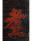Close-up of large red Chinese characters on distressed 19th century wooden signboard with cracks and scratches.