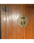 Close-up of brown wooden armoire doors with round brass handles and metal accents.