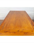 Two-toned brown burl and elm wood antique cabinet beside rectangular wooden table, indoors against white wall.