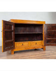 Two-toned burl and elm wood cabinet with doors, antique finish, positioned against a white brick wall indoors.