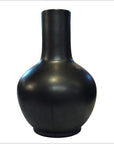 Close-up of a large black celadon vase with round body and long neck, set against a plain white background.