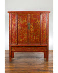 Red lacquer wood armoire with gilt décor, 19th century, on wood floor against a white wall.