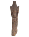 Close-up of brown hand carved wooden Batak Singa Singa tribal carving from Sumatra with intricate swirl patterns.