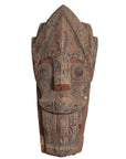 Brown hand-carved wood Singa Singa tribal statue with intricate patterns, Batak people, Sumatra, close-up view.