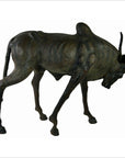 Brown leather gnu sculpture with thin body, curved horns, and lowered head, handmade, close-up view.