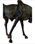 Brown leather gnu sculpture with slender body and lowered head, displayed against a plain white background.