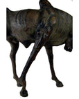 Brown leather gnu sculpture with slender body and lowered head, displayed against a plain white background.