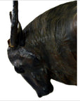 Close-up of a brown leather gnu sculpture with lowered head and one visible horn.