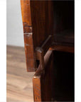 Close-up of brown teak wood joint on large cabinet with four drawers and four double doors.