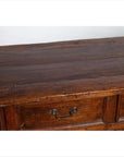 Close-up of brown teak wood cabinet with polished finish, four drawers, and double doors.