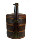 Brown wicker basket with lid, ornate carvings, tall handle, and metal accents on a white background.