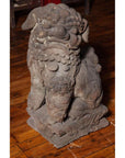 Gray stone lion sculpture on wooden floor, Ming Dynasty Chinese antique, carved details visible.