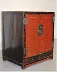 Black and red wood cabinet with chinoiserie doors and two small bottom drawers, front view.