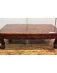 Dark wood low carved table with ornate legs and claw feet, placed on a wooden floor.