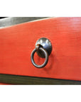 Close-up of red lacquered wood drawer on Low Side Table with central round metal ring pull handle.