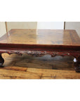 Distressed wood square table with carved elm legs, shown on wooden floor.
