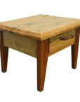 Brown mango wood side table with four legs, rustic finish, front drawer with brass pull, indoors.