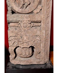 Brown wood Ming Dynasty Chinese temple carvings with figures, floral, and circular motifs on black bases, close-up.
