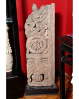 Brown wood Ming Dynasty Chinese temple carvings with figures, floral, and circular motifs on black bases, close-up.