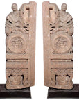 Brown wood Ming Dynasty Chinese temple carvings with figures, floral, and circular motifs on black bases, close-up.