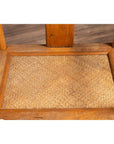 Brown wood and rattan Ming Dynasty style wedding armchair close-up with curved arms, on wood flooring indoors.