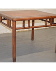 Square elmwood Ming style coffee table with geometric base design and four straight legs on gray floor.