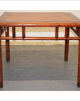 Square elmwood Ming style coffee or side table with rounded edges on a gray floor against a light wall.