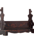 Dark wood mirror stand with floral carvings, black lacquer accents, and cut-out side panels, close-up view.