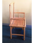 Natural wood chairs with uneven high armrests and a carved apron, showing an asymmetrical geometric silhouette.