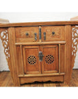 Natural elmwood altar cabinet with carved floral details, two drawers, vented doors, and spandrels, front view.