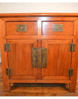 Natural wood small cabinet with two drawers, two doors, and unique hardware on a wooden floor, front view.