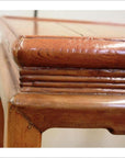 Close-up of natural wood tea table corner, showing horse hoof feet and detailed wood grain texture.