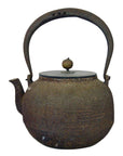 Close-up of rustic iron Japanese teapot with curved handle and round wooden lid knob, in good condition.