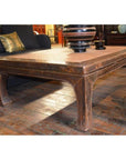 White lacquer coffee table on wooden floor, styled with bowls and decorative items on top.
