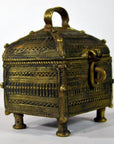 Brass Orissa miniature treasure box with handle, ornate patterns, and four short legs, close-up view.
