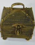 Close-up of small brass Orissa miniature treasure box with intricate patterns, top handle, and front latch.
