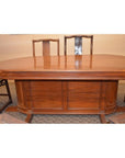 Glossy brown wooden oval pedestal dining table with four matching rustic wooden chairs, dining room setting.