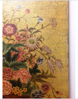 Colorful floral painting on wood with green foliage and cracked yellow background, close-up view.