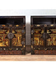 Black and gold antique Chinese wood display cabinets with hand painted chinoiserie motifs, against white brick wall.