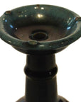 Close-up of dark green glazed ceramic antique Chinese Hunan candle holders with wide tops and narrow stems.