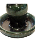 Close-up of a pair of dark green glazed ceramic antique Chinese Hunan candle holders with rounded bases.