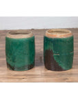 Green glazed ceramic Chinese planters with rustic finish on wooden floor against a white wall.
