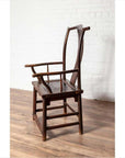 Brown wood Chinese 1880s Official's Hat Chairs with carved splats on rustic wooden floor against white brick wall.