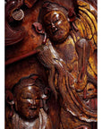 Brown and gold wood Chinese carvings with serene expressions and flowing robes, close-up view.
